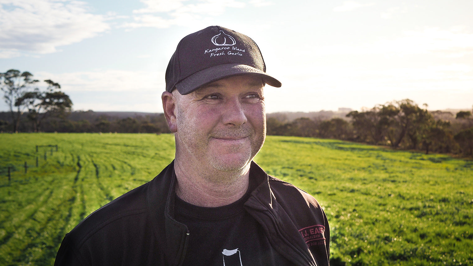 A man (Shane) smiling in a green field.